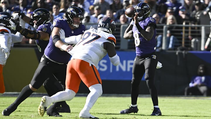 Baltimore Ravens quarterback Lamar Jackson (8) throws as Denver Broncos defensive tackle Malcolm Roach (97) applies pressure during the first quarter at M&T Bank Stadium. 