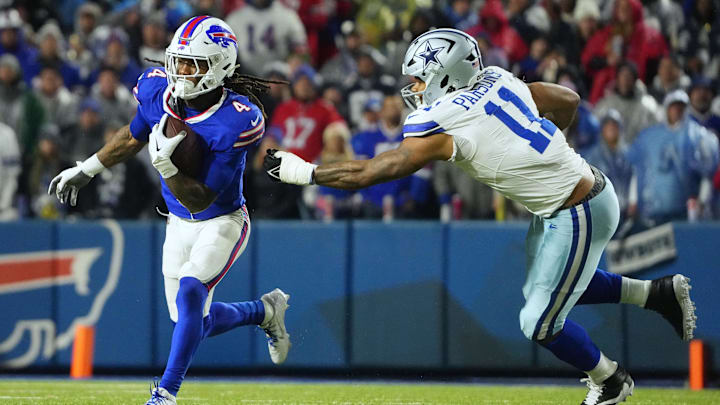 Buffalo Bills running back James Cook runs the ball, pressured by Dallas Cowboys linebacker Micah Parsons.
