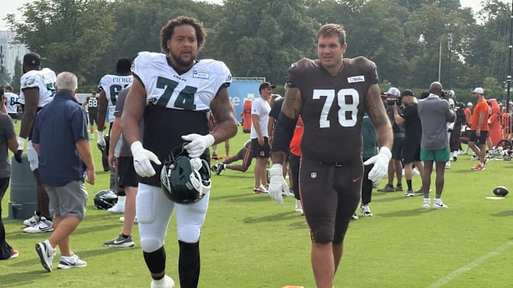 Offensive tackles Kendall Lamm of the Eagles (74) and Jack Conkin of the Browns head to a drill during their practice on Aug. 13, 2025.