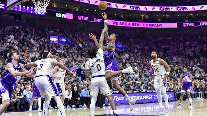 Dec 1, 2024; Salt Lake City, Utah, USA; Utah Jazz forward/center John Collins (20) gets fouled by Los Angeles Lakers guard Jalen Hood-Schifino (0) during the first half at the Delta Center. Mandatory Credit: Christopher Creveling-Imagn Images