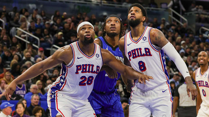 Jan 12, 2025; Orlando, Florida, USA; Philadelphia 76ers forward Guerschon Yabusele (28) and forward Paul George (8) defend Orlando Magic center Wendell Carter Jr. (34) for the rebound during the second half at Kia Center. Mandatory Credit: Mike Watters-Imagn Images