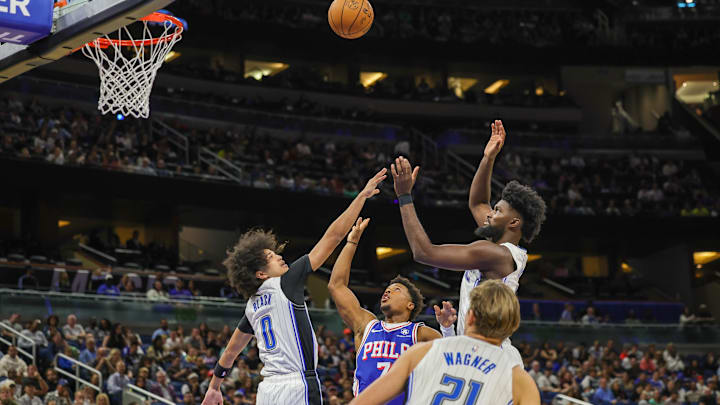 Oct 18, 2024; Orlando, Florida, USA; Philadelphia 76ers guard Kyle Lowry (7), Orlando Magic guard Anthony Black (0) and forward Jonathan Isaac (1) jump for the rebound during the second quarter at Kia Center. Mandatory Credit: Mike Watters-Imagn Images