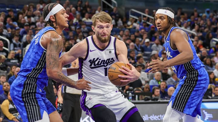 Sacramento Kings forward Domantas Sabonis (10) drives to the basket against Orlando Magic forward Paolo Banchero (5) and Orlando Magic center Wendell Carter Jr. (34) during the first quarter at KIA Center.