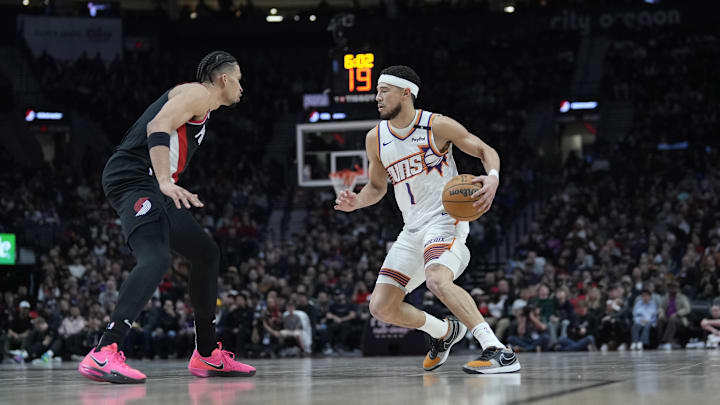 Feb 1, 2025; Portland, Oregon, USA; Phoenix Suns shooting guard Devin Booker (1) dribbles the ball against Portland Trail Blazers forward Toumani Camara (33, left) during the first half at Moda Center. Mandatory Credit: Soobum Im-Imagn Images