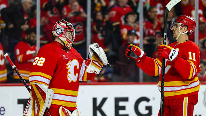 Apr 11, 2025; Calgary, Alberta, CAN; Calgary Flames goaltender Dustin Wolf (32) celebrate win with center Mikael Backlund (11) after defeating the Minnesota Wild at Scotiabank Saddledome. Mandatory Credit: Sergei Belski-Imagn Images