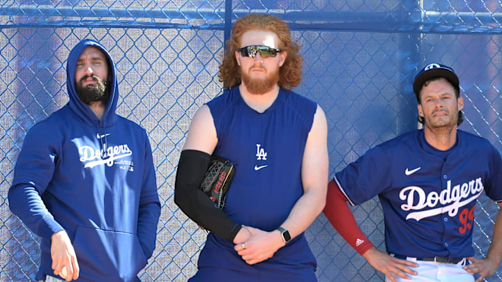 Feb 18, 2024; Glendale, AZ, USA;  Los Angeles Dodgers starting pitcher Tony Gonsolin (26), starting pitcher Dustin May (85) and relief pitcher Joe Kelly (99) lean on a fence in the bull pen during spring training at Camelback Ranch. Mandatory Credit: Jayne Kamin-Oncea-Imagn Images