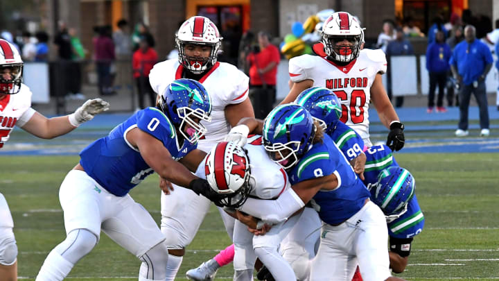 Cameron Jackson (0) and Justin Hill (8) drop Nathan Webster for a only a short gain for the Eagles at Winton Woods Stadium, Oct. 6, 2023.