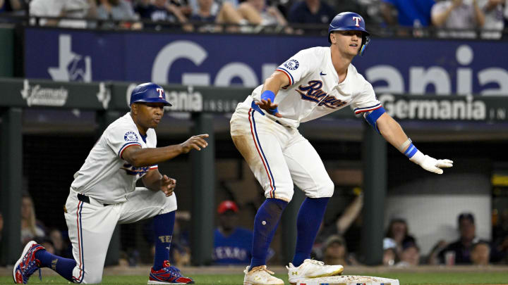 Mar 31, 2024; Arlington, Texas, USA; Texas Rangers third baseman Josh Jung (6) and third base coach Tony Beasley (27) celebrate after Jung hits a triple against the Chicago Cubs during the game at Globe Life Field. Mandatory Credit: Jerome Miron-USA TODAY Sports