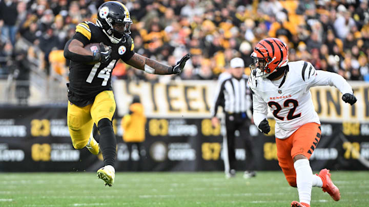 Nov 16, 2025; Pittsburgh, Pennsylvania, USA; Pittsburgh Steelers running back Kenneth Gainwell (14) leaps in the air while running with the ball against Cincinnati Bengals safety Geno Stone (22) during the second half at Acrisure Stadium. Mandatory Credit: Barry Reeger-Imagn Images