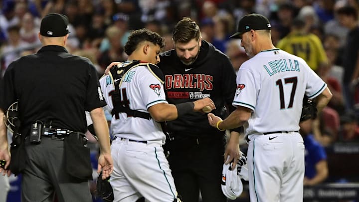 Oct 11, 2023; Phoenix, Arizona, USA; Arizona Diamondbacks manager Torey Lovullo (17) talks with Arizona Diamondbacks catcher Gabriel Moreno (14) after an injury against the Los Angeles Dodgers in the fifth inning for game three of the NLDS for the 2023 MLB playoffs at Chase Field. Mandatory Credit: Matt Kartozian-Imagn Images