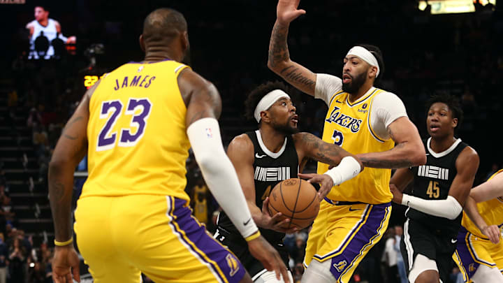 Apr 12, 2024; Memphis, Tennessee, USA; Memphis Grizzlies guard Jordan Goodwin (4) drives to the basket between Los Angeles Lakers forward LeBron James (23) and forward Anthony Davis (3) during the second half at FedExForum. Mandatory Credit: Petre Thomas-USA TODAY Sports