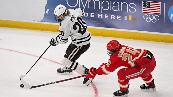 Apr 10, 2025; St. Louis, Missouri, UNITED STATES; Denver Pioneers forward Kieran Cebrian (24) and Western Michigan Broncos forward Alex Bump (20) battle for control of the puck during the first period of the Frozen Four college ice hockey national semifinals at Enterprise Center. Mandatory Credit: Connor Hamilton-Imagn Images