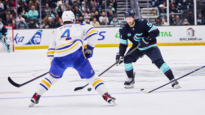 Dec 14, 2025; Seattle, Washington, USA; Seattle Kraken center Shane Wright (51) looks to pass as Buffalo Sabres defenseman Bowen Byram (4) defends during the second period at Climate Pledge Arena. Mandatory Credit: Blake Dahlin-Imagn Images