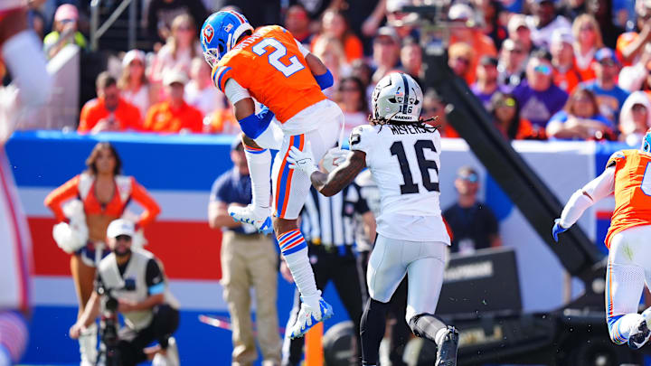 Oct 6, 2024; Denver, Colorado, USA; Denver Broncos cornerback Pat Surtain II (2) pulls in an interception intended for Las Vegas Raiders wide receiver Jakobi Meyers (16) in the second quarter at Empower Field at Mile High. 