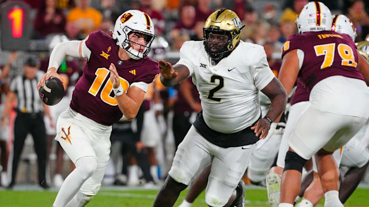 ASU quarterback Sam Leavitt (10) scrambles against UCF defensive tackle Lee Hunter (2) during a game at Mountain America Stadium in Tempe on Nov. 9, 2024.