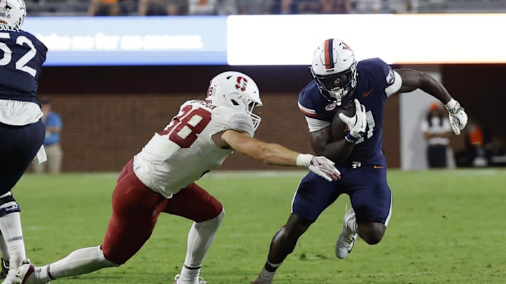 Sep 20, 2025; Charlottesville, Virginia, USA; Virginia Cavaliers running back Harrison Waylee (21) carries the ball as Stanford Cardinal linebacker Zach Johnson (38) attempts a tackle during the fourth quarter at Scott Stadium. Mandatory Credit: Geoff Burke-Imagn Images