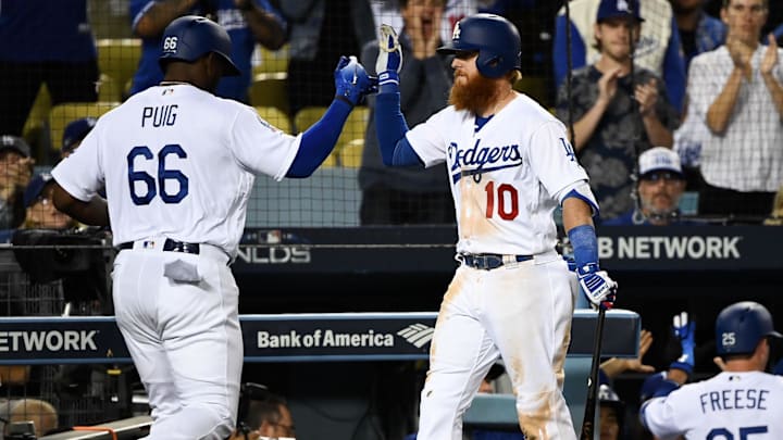 Oct 4, 2018; Los Angeles, CA, USA; Los Angeles Dodgers right fielder Yasiel Puig (66) high-fives third baseman Justin Turner (10) after scoring in the eighth inning Atlanta Braves in game one of the 2018 NLDS playoff baseball series at Dodger Stadium. Mandatory Credit: Robert Hanashiro-Imagn Images