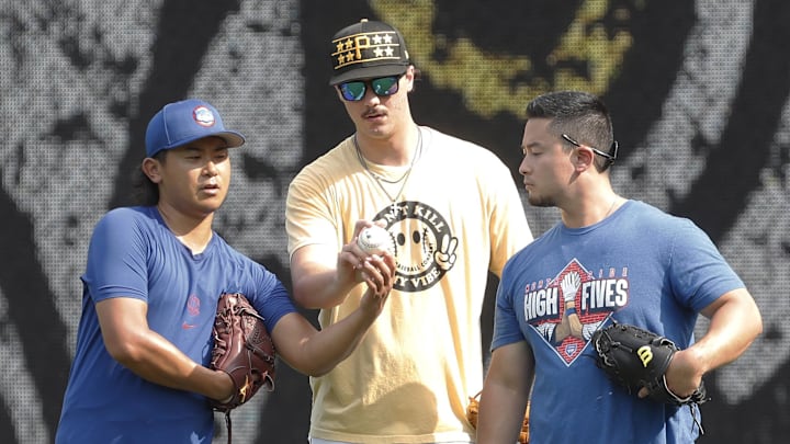 Chicago Cubs pitcher Shota Imanaga (left) and Pittsburgh Pirates pitcher Paul Skenes (middle) discuss pitching grips as Edwin Stanberry (right) interprets before the Pirates host the Cubs at PNC Park on August 27, 2024. 