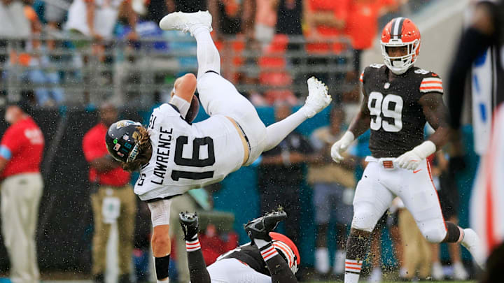 Jacksonville Jaguars quarterback Trevor Lawrence (16) is upended by Cleveland Browns linebacker Jeremiah Owusu-Koramoah (6) as defensive end Za'Darius Smith (99) looks on during the fourth quarter of an NFL football matchup Sunday, Sept. 15, 2024 at EverBank Stadium in Jacksonville, Fla. 