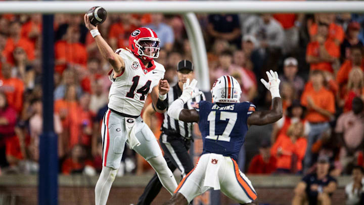 Georgia Bulldogs quarterback Gunner Stockton (14) throws the ball with pressure from Auburn Tigers linebacker Xavier Atkins (17) as Auburn Tigers take on Georgia Bulldogs at Jordan-Hare Stadium in Auburn, Ala. on Saturday, Oct. 11, 2025.
