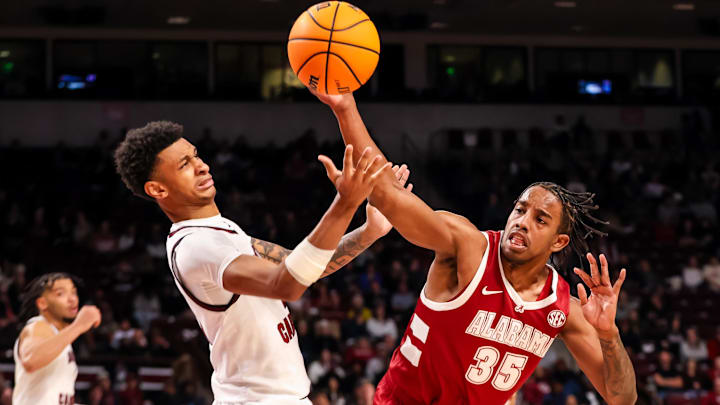 Jan 8, 2025; Columbia, South Carolina, USA; South Carolina Gamecocks guard Arden Conyers (21) and Alabama Crimson Tide forward Derrion Reid (35) battle for a rebound in the second half at Colonial Life Arena. Mandatory Credit: Jeff Blake-Imagn Images