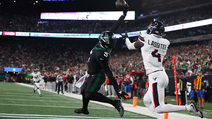 Oct 31, 2024; East Rutherford, New Jersey, USA; New York Jets wide receiver Garrett Wilson (5) catches a touchdown pass while being defended by Houston Texans cornerback Kamari Lassiter (4) during the second half at MetLife Stadium. Oct 31, 2024; East Rutherford, New Jersey, USA; New York Jets wide receiver Garrett Wilson (5) catches a touchdown pass while being defended by Houston Texans cornerback Kamari Lassiter (4) during the second half at MetLife Stadium.