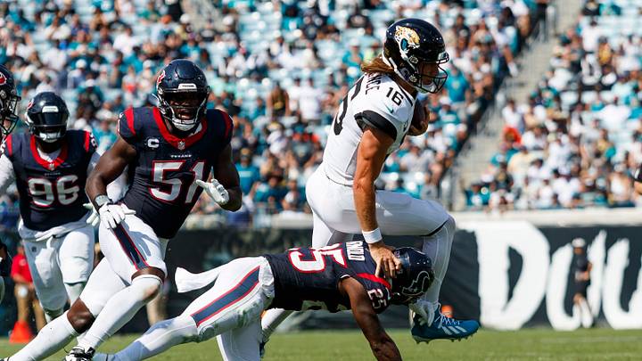 Sep 24, 2023; Jacksonville, Florida, USA; Jacksonville Jaguars quarterback Trevor Lawrence (16) jumps over a tackle from Houston Texans safety Grayland Arnold (25) with defensive end Will Anderson Jr. (51) and linebacker Henry To'oTo'o (39) running close behind during the third quarter at EverBank Stadium. Mandatory Credit: Morgan Tencza-USA TODAY Sports