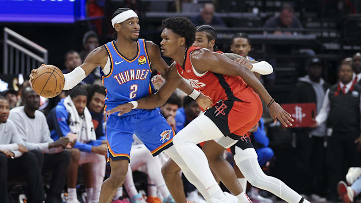 Dec 1, 2024; Houston, Texas, USA; Oklahoma City Thunder guard Shai Gilgeous-Alexander (2) controls the ball as Houston Rockets forward Amen Thompson (1) defends during the game at Toyota Center. Mandatory Credit: Troy Taormina-Imagn Images Dec 1, 2024; Houston, Texas, USA; Oklahoma City Thunder guard Shai Gilgeous-Alexander (2) controls the ball as Houston Rockets forward Amen Thompson (1) defends during the game at Toyota Center. Mandatory Credit: Troy Taormina-Imagn Images