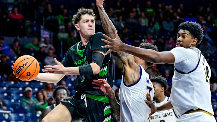 Nov 19, 2024; South Bend, Indiana, USA; North Dakota Fighting Hawks guard Treysen Eaglestaff (52) passes the ball as Notre Dame Fighting Irish forward Tae Davis (7) and forward Kebba Njie (14) defend in the second half at the Purcell Pavilion. Mandatory Credit: Matt Cashore-Imagn Images