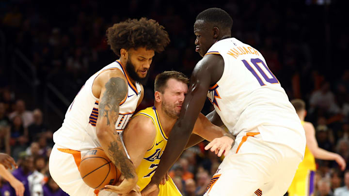 Oct 14, 2025; Phoenix, Arizona, USA; Los Angeles Lakers guard Luka Doncic (77) reacts as he collides with Phoenix Suns center Khaman Maluach (10) alongside forward Isaiah Livers (18) during an NBA preseason game at Mortgage Matchup Center. Mandatory Credit: Mark J. Rebilas-Imagn Images
Oct 14, 2025; Phoenix, Arizona, USA; Los Angeles Lakers guard Luka Doncic (77) reacts as he collides with Phoenix Suns center Khaman Maluach (10) alongside forward Isaiah Livers (18) during an NBA preseason game at Mortgage Matchup Center. Mandatory Credit: Mark J. Rebilas-Imagn Images