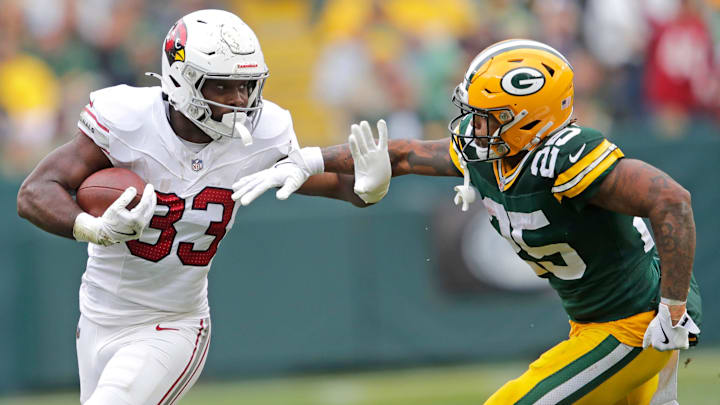 Arizona Cardinals running back Trey Benson (33) runs for a first down against Green Bay Packers cornerback Keisean Nixon (25) in the third quarter during their football game Sunday, October 13, 2024, at Lambeau Field in Green Bay, Wisconsin. Arizona Cardinals running back Trey Benson (33) runs for a first down against Green Bay Packers cornerback Keisean Nixon (25) in the third quarter during their football game Sunday, October 13, 2024, at Lambeau Field in Green Bay, Wisconsin.
