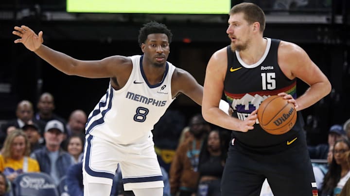 Nov 24, 2025; Memphis, Tennessee, USA; Denver Nuggets center Nikola Jokic (15) handles the ball as Memphis Grizzlies forward/center Jaren Jackson Jr. (8) defends during the fourth quarter at FedExForum. Mandatory Credit: Petre Thomas-Imagn Images
