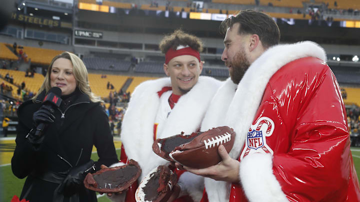 Kansas City Chiefs quarterback Patrick Mahomes (middle) and tight end Travis Kelce (right) open their Netflix Christmas GameDay cake after the Chiefs defeated the Pittsburgh Steelers at Acrisure Stadium. 