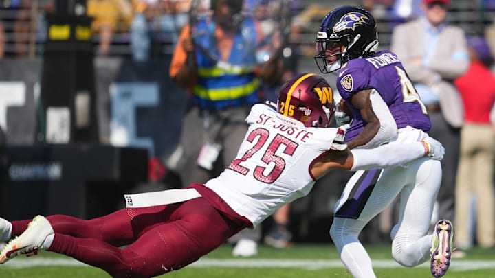 Oct 13, 2024; Baltimore, Maryland, USA; Baltimore Ravens wide receiver Zay Flowers (4) catches a second quarter pass defended by Washington Commanders cornerback Benjamin St-Juste (25) at M&T Bank Stadium. Mandatory Credit: Mitch Stringer-Imagn Images
