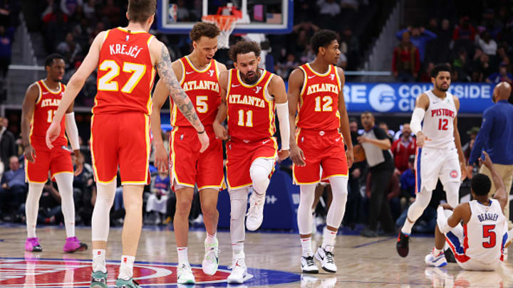 Trae Young celebrates a game-winner against the Pistons after stepping over Malik Beasley.