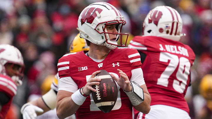 Nov 29, 2024; Madison, Wisconsin, USA;  Wisconsin Badgers quarterback Braedyn Locke (18) looks to throw a pass during the first quarter against the Minnesota Golden Gophers at Camp Randall Stadium.