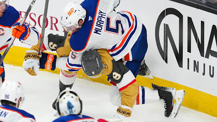 Mar 26, 2026; Las Vegas, Nevada, USA; Edmonton Oilers defenseman Connor Murphy (5) takes down Vegas Golden Knights center Jack Eichel (9) during the third period at T-Mobile Arena. Mandatory Credit: Stephen R. Sylvanie-Imagn Images
