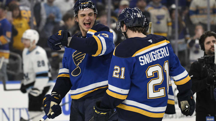 Apr 15, 2025; St. Louis, Missouri, USA; St. Louis Blues right wing Alexey Toropchenko (13) reacts with right wing Jimmy Snuggerud (21) after a win against the Utah Hockey Club at Enterprise Center to clinch a spot in the playoffs. Mandatory Credit: Jeff Le-Imagn Images