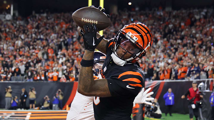 Dec 28, 2024; Cincinnati, Ohio, USA;  Cincinnati Bengals  wide receiver Tee Higgins (5) catches a touchdown as Denver Broncos cornerback Riley Moss (21) defends during the fourth quarter at Paycor Stadium.