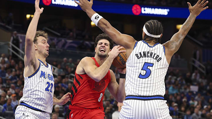 Nov 10, 2025; Orlando, Florida, USA; Portland Trail Blazers forward Deni Avdija (8) drives to the basket past Orlando Magic forward Franz Wagner (22) and forward Paolo Banchero (5) in the first quarter  at Kia Center. Mandatory Credit: Nathan Ray Seebeck-Imagn Images