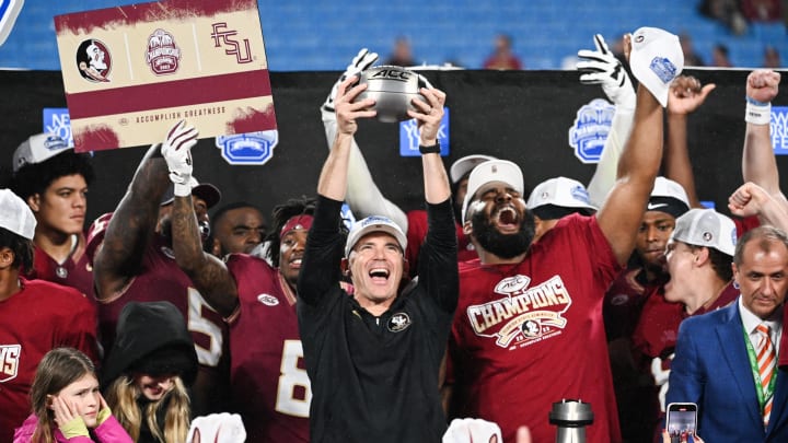 Dec 2, 2023; Charlotte, NC, USA; Florida State Seminoles head coach Mike Norvell raises the ACC Championship trophy with his players after the game against the Louisville Cardinals at Bank of America Stadium. Mandatory Credit: Bob Donnan-USA TODAY Sports