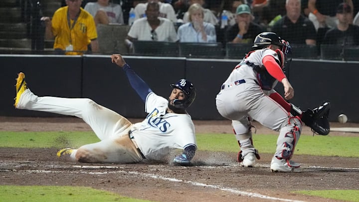 Sep 21, 2025; Tampa, Florida, USA; Tampa Bay Rays third base Junior Caminero (13) slides safely into home as he scores off a hit by outfielder Christopher Morel (24) as Boston Red Sox catcher Connor Wong (12) tries to make the tag during the eighth inning at George M. Steinbrenner Field. Mandatory Credit: Dave Nelson-Imagn Images