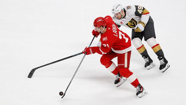 Mar 4, 2026; Detroit, Michigan, USA;  Detroit Red Wings center Dylan Larkin (71) skates with the puck chased by Vegas Golden Knights left wing Ivan Barbashev (49) in the first period at Little Caesars Arena. Mandatory Credit: Rick Osentoski-Imagn Images