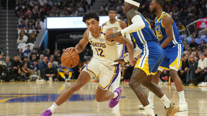 Dec 25, 2024; San Francisco, California, USA; Los Angeles Lakers guard Max Christie (12) dribbles against Golden State Warriors guard Dennis Schroder (center right) during the second quarter at Chase Center. Mandatory Credit: Darren Yamashita-Imagn Images
