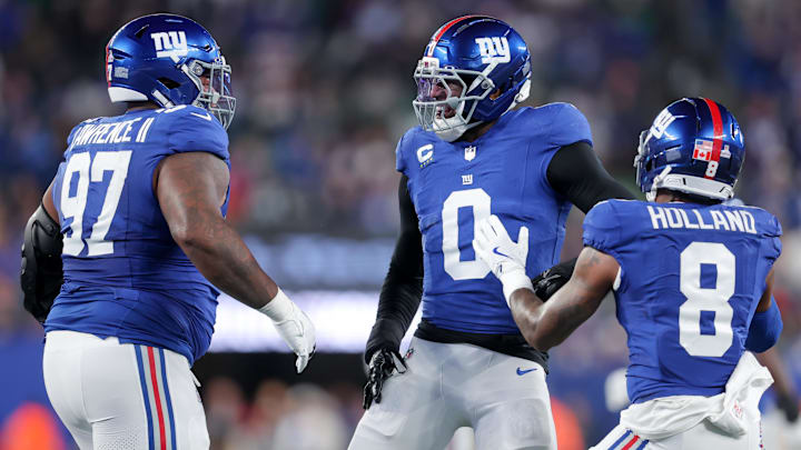 Oct 9, 2025; East Rutherford, New Jersey, USA; New York Giants linebacker Brian Burns (0) celebrates after a sack against the Philadelphia Eagles with defensive tackle Dexter Lawrence II (97) and safety Jevon Holland (8) during the first quarter of the game at MetLife Stadium. Mandatory Credit: Brad Penner-Imagn Images