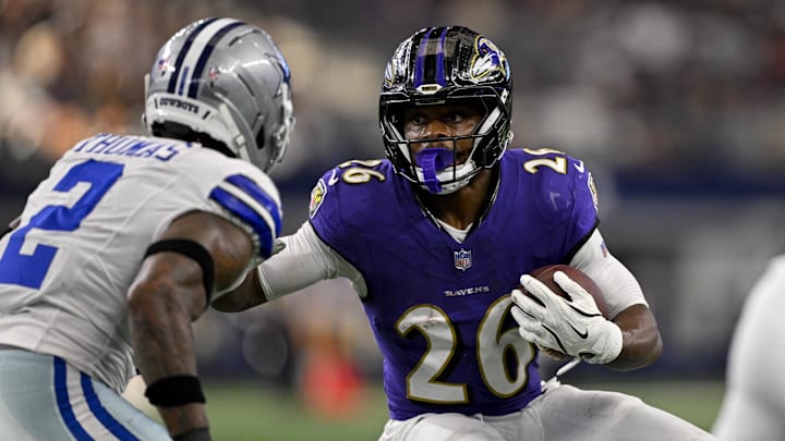 Aug 16, 2025; Arlington, Texas, USA; Baltimore Ravens running back Rasheen Ali (26) attempts to elude Dallas Cowboys safety Juanyeh Thomas (2) during the first quarter at AT&T Stadium. Mandatory Credit: Jerome Miron-Imagn Images