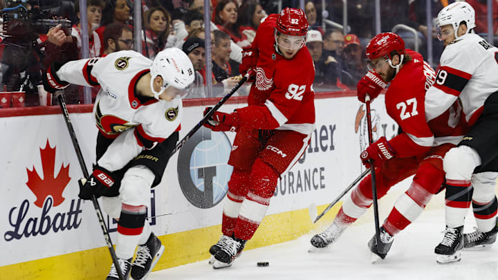 Mar 27, 2025; Detroit, Michigan, USA;  Detroit Red Wings center Marco Kasper (92) and Ottawa Senators center Tim Stutzle (18) battle for the puck in the second period at Little Caesars Arena. Mandatory Credit: Rick Osentoski-Imagn Images