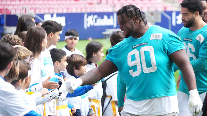 Miami Dolphins defensive tackle Kenneth Grant (90) interacts with community flag football clinic participants at Estadio Riyadh Air Metropolitano. 