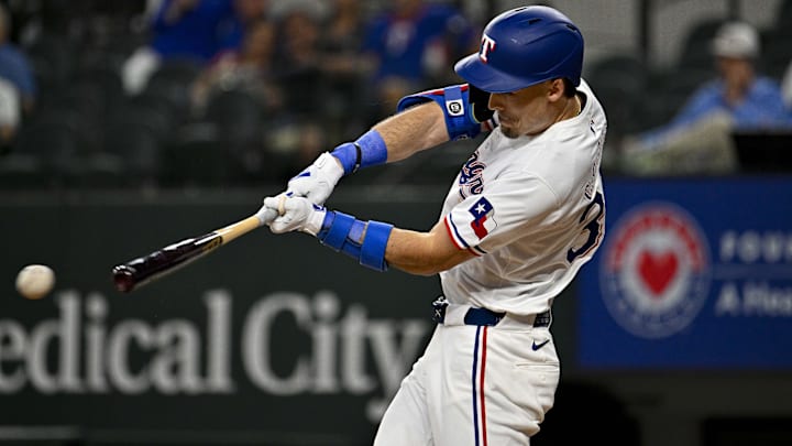 May 2, 2024; Arlington, Texas, USA; Texas Rangers center fielder Evan Carter (32) hits a singles and drives in a run against the Washington Nationals during the second inning at Globe Life Field. Mandatory Credit: Jerome Miron-Imagn Images