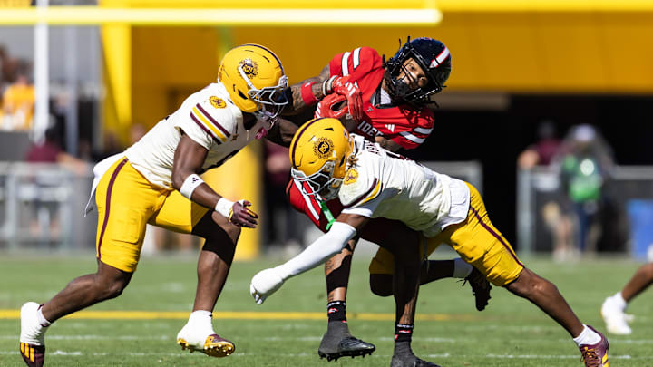 Oct 18, 2025; Tempe, Arizona, USA; Texas Tech Red Raiders wide receiver Caleb Douglas (5) is tackled by Arizona State Sun Devils defensive back Keith Abney II (1) and linebacker Jordan Crook (8) in the first half at Mountain America Stadium. Mandatory Credit: Mark J. Rebilas-Imagn Images Oct 18, 2025; Tempe, Arizona, USA; Texas Tech Red Raiders wide receiver Caleb Douglas (5) is tackled by Arizona State Sun Devils defensive back Keith Abney II (1) and linebacker Jordan Crook (8) in the first half at Mountain America Stadium. Mandatory Credit: Mark J. Rebilas-Imagn Images